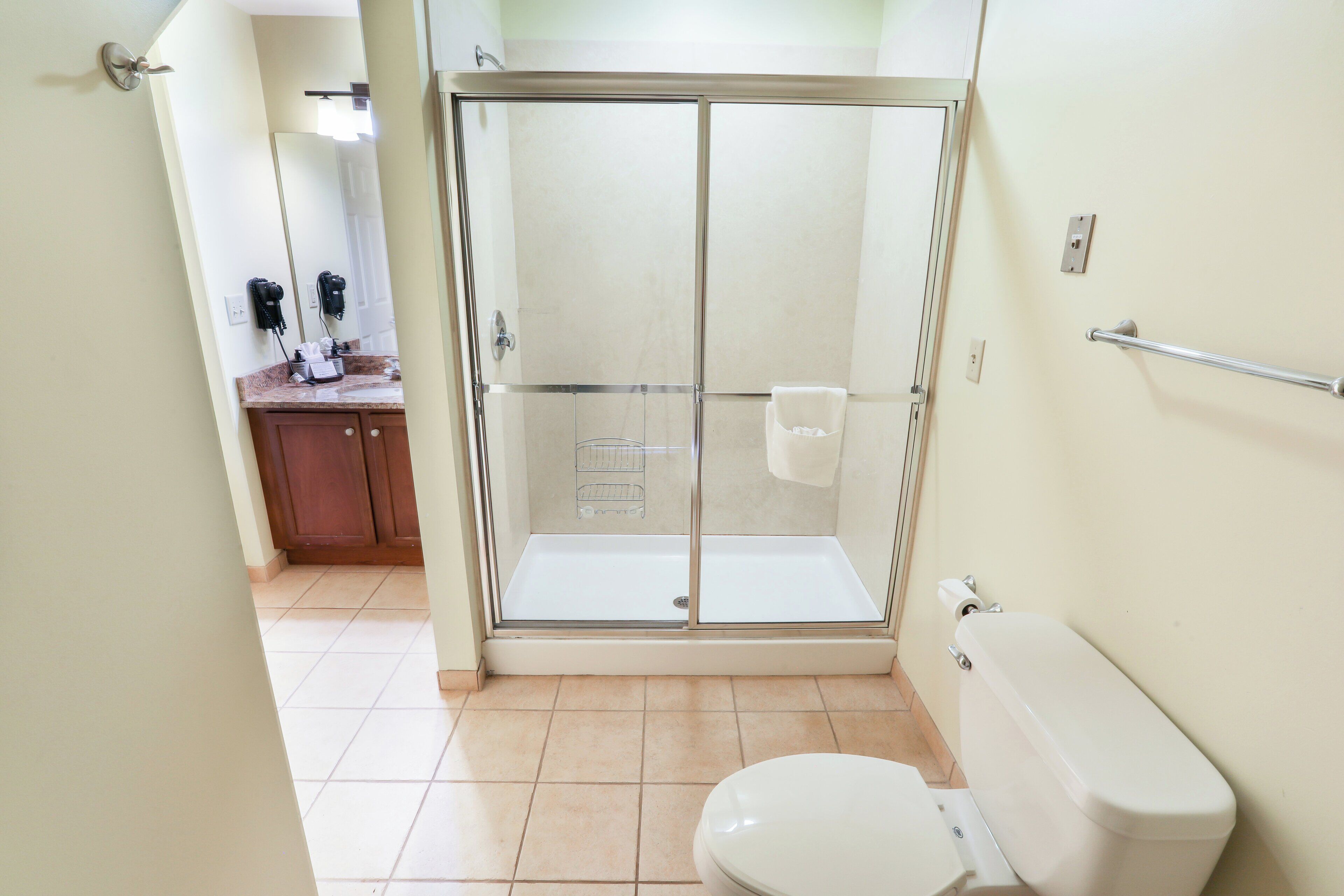 Une salle de bain avec une douche à parois de verre, des toilettes et un lavabo avec un miroir.