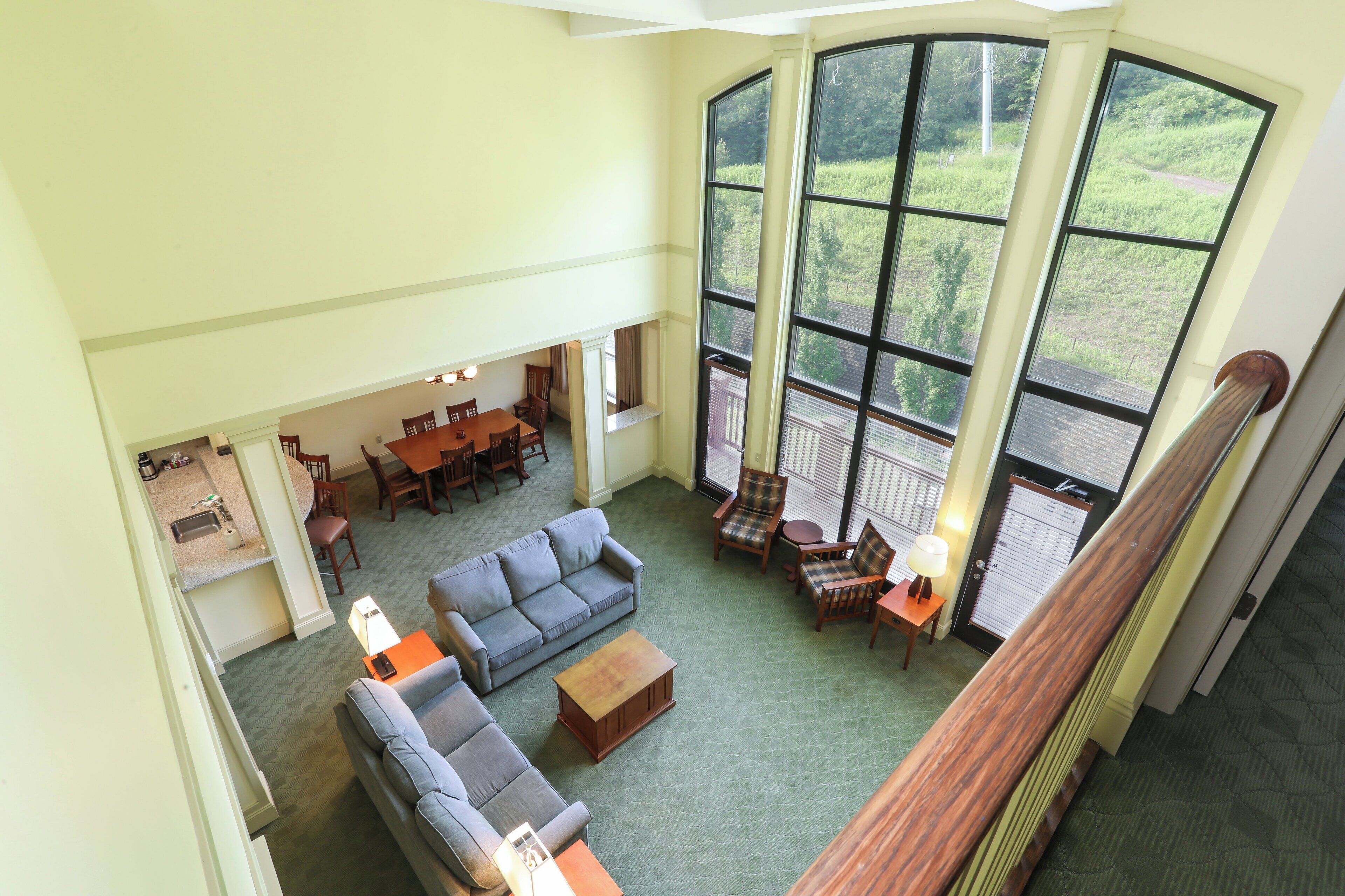 A spacious living room with a large window, a dining area, and a kitchen.