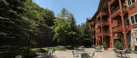 A courtyard with outdoor seating and a building with balconies.