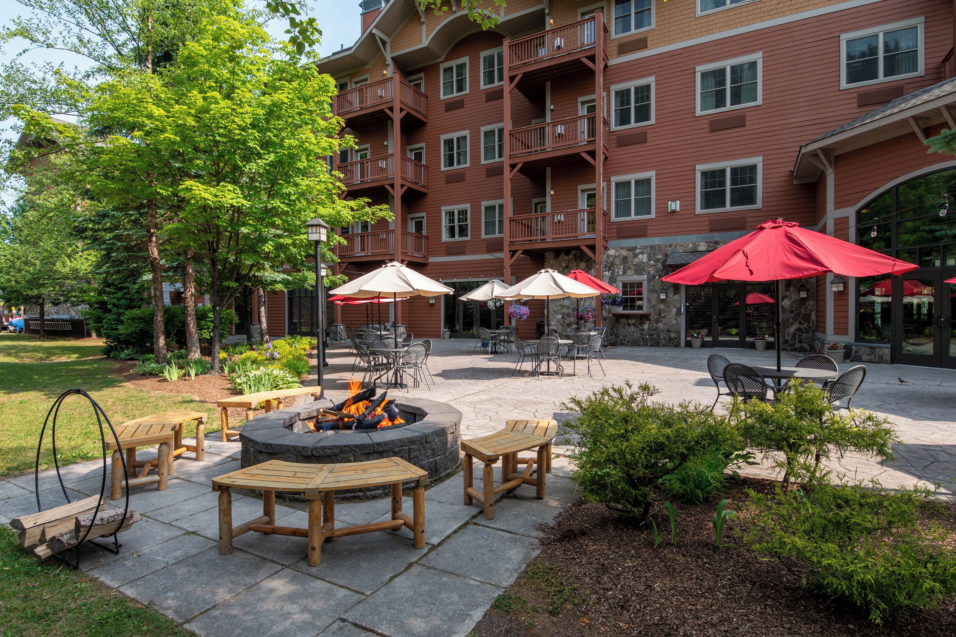 A courtyard with outdoor seating, a fire pit, and a building with multiple balconies.