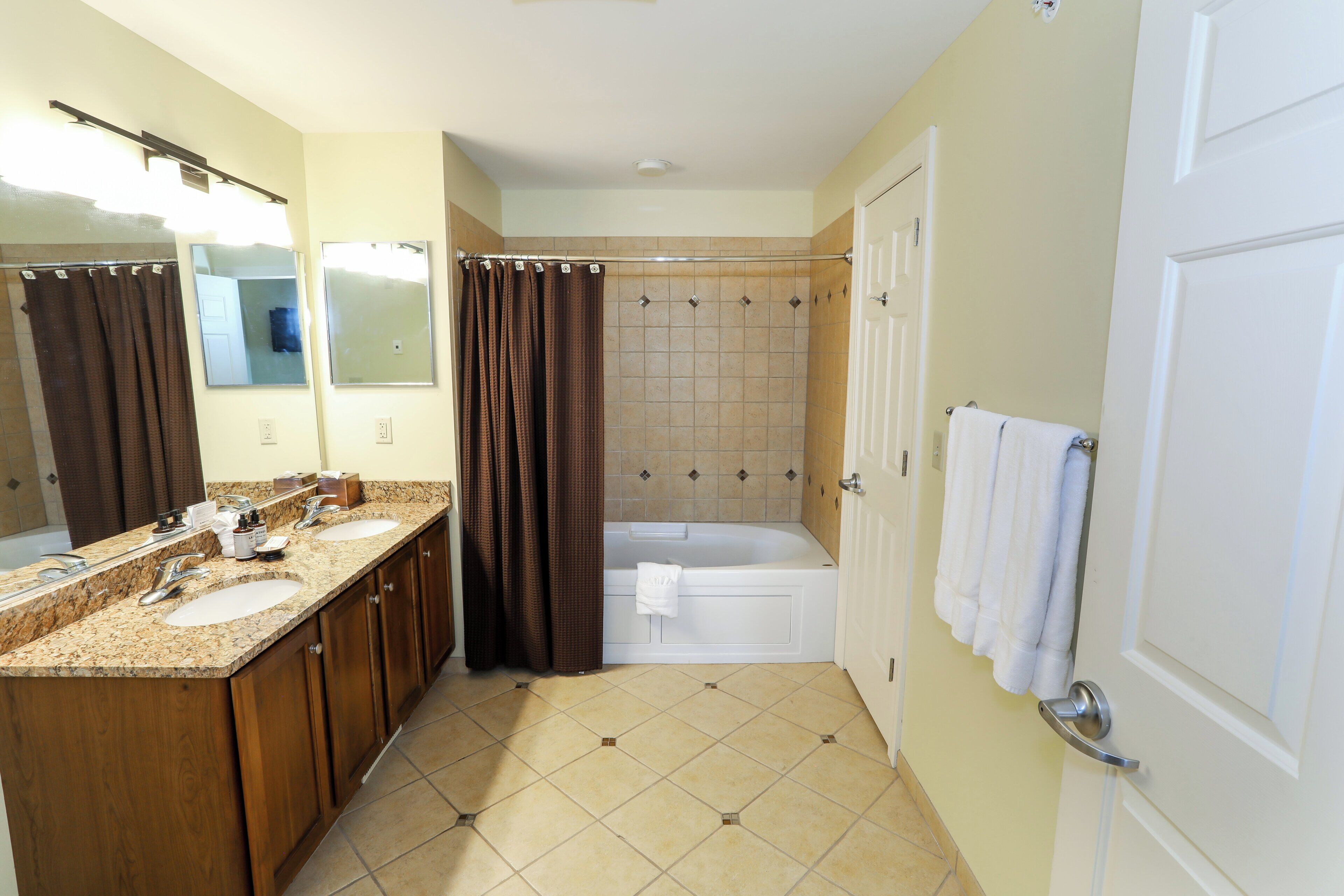 A bathroom with two sinks, a bathtub, and a shower.