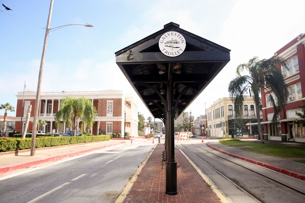 A street sign with a circular emblem and a triangular shelter.