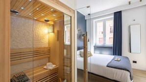 Une chambre d’hôtel moderne équipée d’un sauna, d’un lit, d’une grande fenêtre et offrant une vue sur l’extérieur.