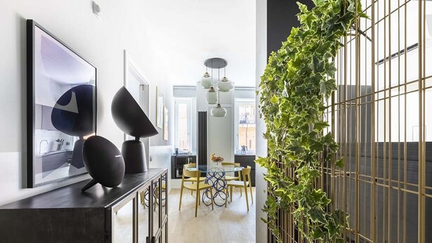 Une cuisine moderne avec un coin repas, une grande fenêtre et un jardin vertical.