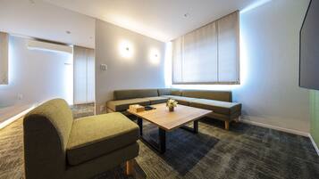 A modern living room with a sofa, a coffee table, and a television.