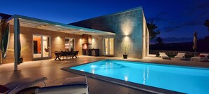 A modern outdoor pool area with a dining setup and lounge chairs. - Brand-new, luxury ***** villa with a heated pool, just 2 km from the ocean (Rakalj)