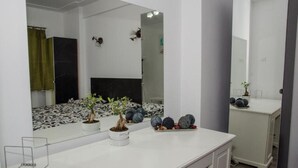 A modern bathroom with a white vanity, a large mirror, and a potted plant. - Central Apartment Bucharest (București)