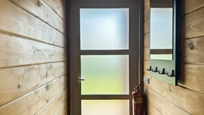 A wooden door with frosted glass panels and a fire extinguisher mounted on the wall. - Gorgeous home in HEEL with WiFi (HEEL)