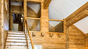 A wooden cabin interior with a staircase leading to a loft area. - Gorgeous home in HEEL with WiFi (HEEL)
