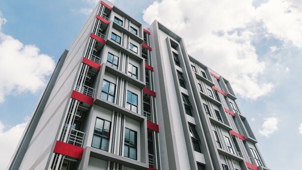 Un edificio a più piani dal design architettonico moderno, con balconi e ampie finestre.