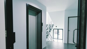 Un corridoio con una porta, una scala e un'altra porta con il maniglia.