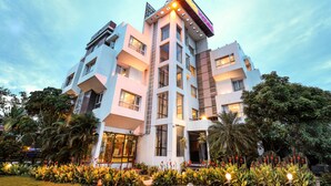 Un hotel de varios pisos con un diseño arquitectónico moderno, que cuenta con balcones y ventanas amplias.