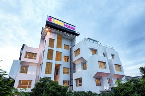 Hotel moderno com design arquitetônico único, com várias varandas e janelas amplas.