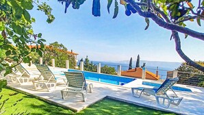 A pool area with lounge chairs and a view of the sea. - Lovely home in Novi Vinodolski (Novi Vinodolski)