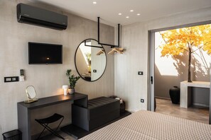 A modern bedroom with a bed, a desk, a mirror, a TV, and a large window with a tree view. - Kumo Villa II - Luxe Coastal Escape with Sea Views (Rethymno)