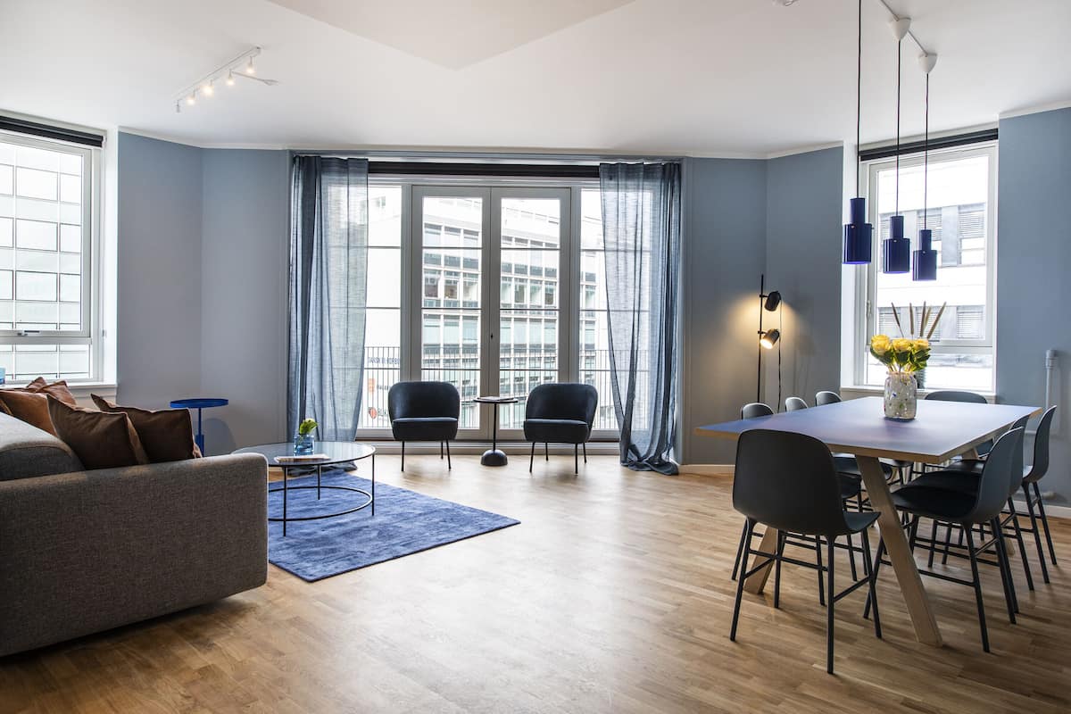 Un salon moderne comprenant un canapé, une table basse et un coin repas avec des chaises et une table.
