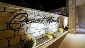 A stone wall with a sign reading "Cathy's Place" and three cacti in a planter. - Cemal Alaçatı Hotel (Cesme)