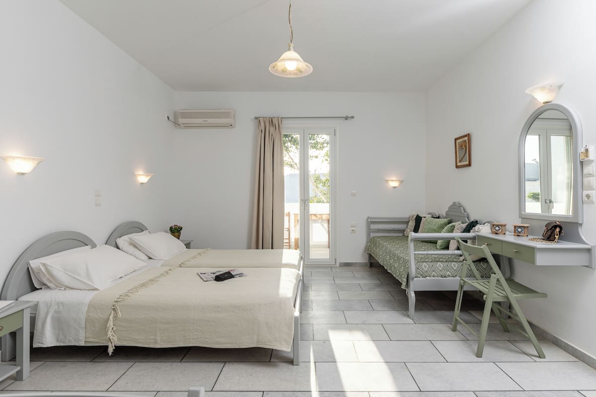 A bedroom with a bed, a desk, a chair, and a window.