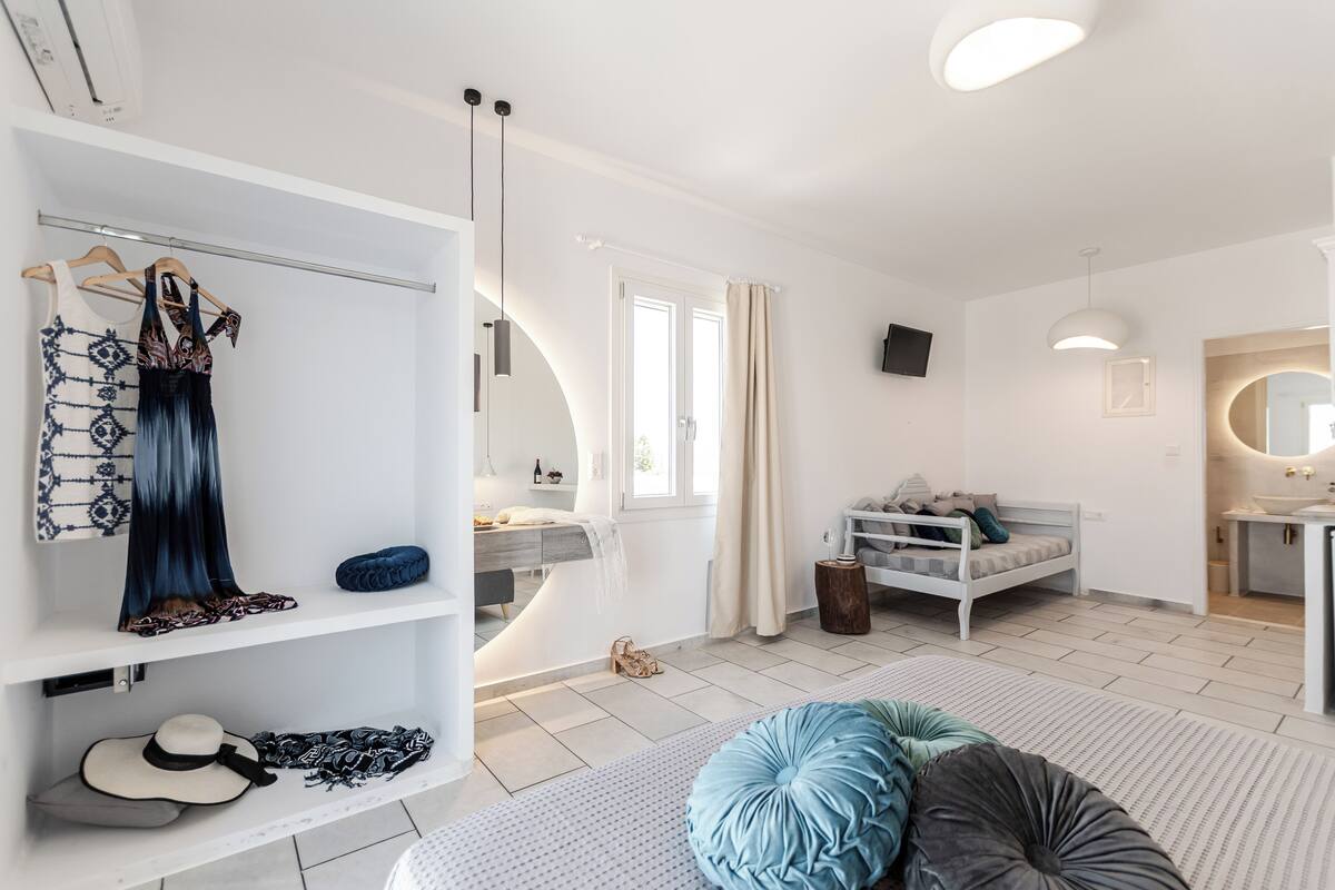 A modern, well-lit bedroom with a bed, bedside table, and a wardrobe.