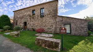 A rustic stone building with a sign reading "Hotel Rustico da Motta."