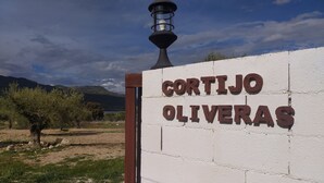 A sign for "CORTIJO OLIVERAS" with a lamp post and a mountainous landscape in the background. - Cortijo oliveras Moratalla (Moratalla)