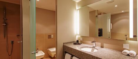 A modern bathroom with a glass shower enclosure, a sink, and a large mirror.