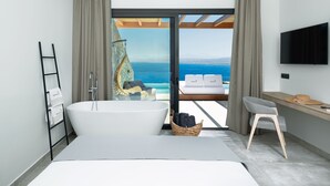 Un baño moderno con una bañera grande, ducha y vistas al océano.