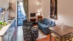 Una sala de estar con sofá, mesa de comedor, televisor y chimenea.