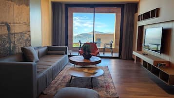 Deluxe Suite | Living area | 65-inch Smart TV with satellite channels