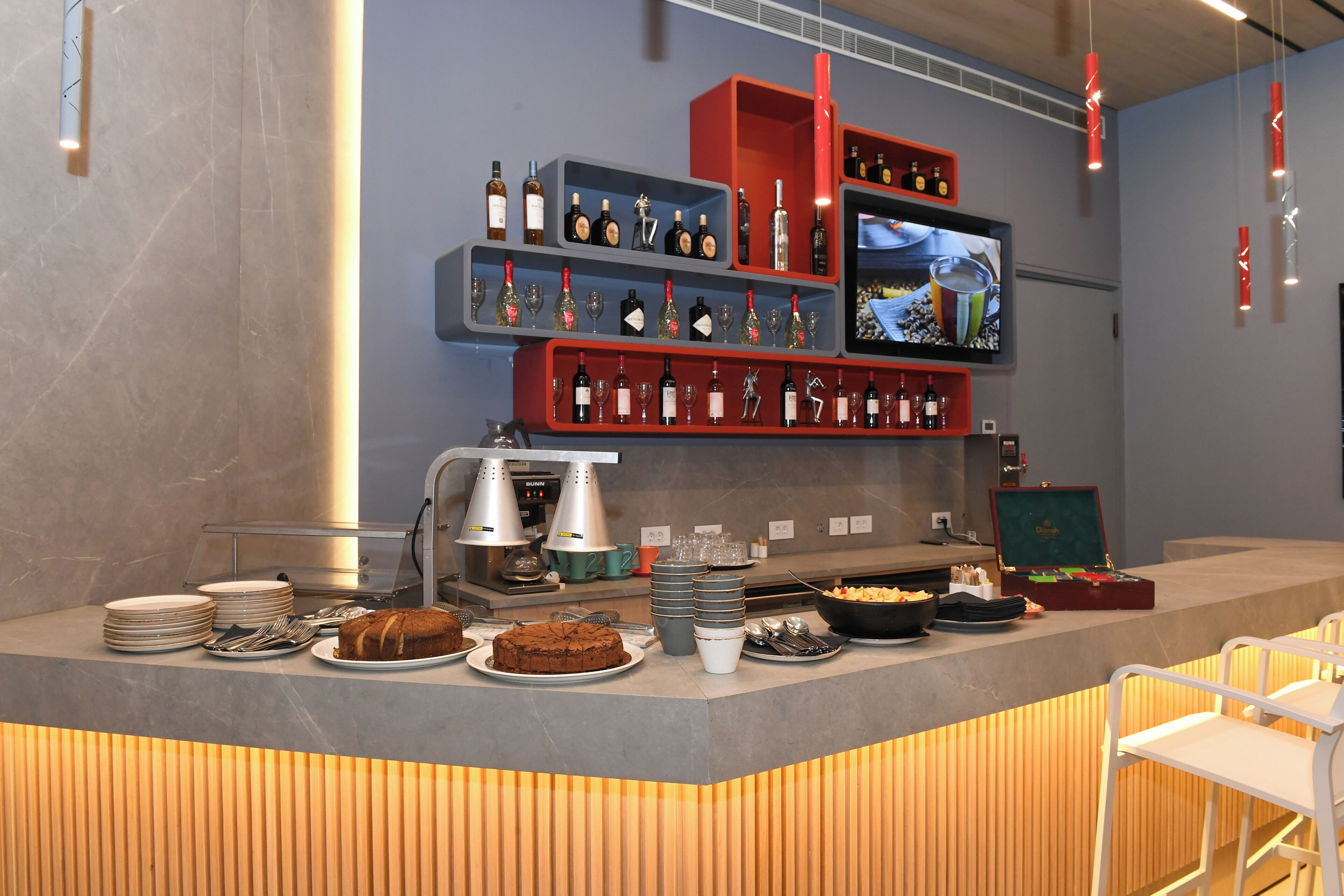 A buffet setup with various food items, plates, and utensils.