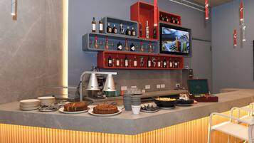 A buffet setup with various food items, plates, and utensils.