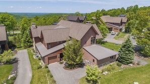 A residential area with multiple houses, a driveway, and a large tree. - Dog Friendly Mountain Retreat w/ Hot Tub & Views (McHenry)