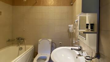 Une salle de bain avec une baignoire, des toilettes et un lavabo.