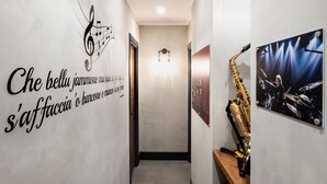 A hallway with a saxophone, a wall with a musical note and text, and a framed picture of a drummer. - CasaJammone Naples Bed&Breakfast (Naples)