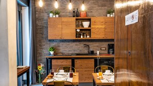 A modern kitchen with wooden cabinets, a brick wall, and pendant lighting. - CasaJammone Naples Bed&Breakfast (Naples)