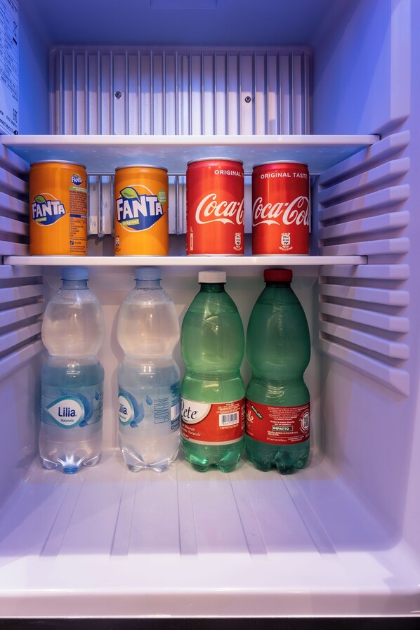 A refrigerator with Fanta, Coca-Cola, and various water bottles.