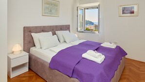 Une chambre à coucher avec un lit, une table de chevet et une fenêtre donnant sur un beau paysage.