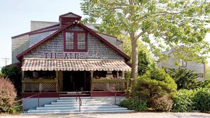 A wooden building with a sign reading "THEATRE by the Sea".
