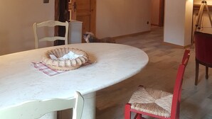 Een eethoek met een ronde tafel, stoelen en een houten plafond.