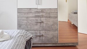 A bedroom with a bed, a wardrobe with a mirror, and a door leading to another room. - Modern Apartment in The Heart of Vienna 1 (Vienna)