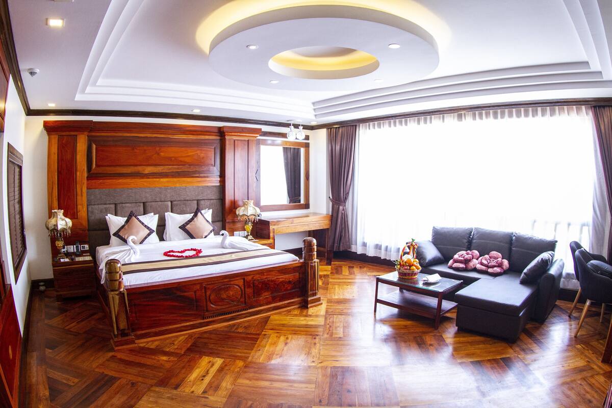 Un dormitorio amplio con una cama grande, un sofá y una mesita de centro.