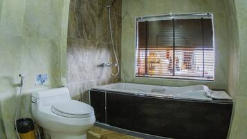 Un baño con inodoro, ducha y bañera.