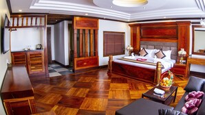 Ein geräumiges Schlafzimmer mit einem großen Bett, Holzmöbeln und einem karierten Boden.