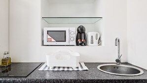 A modern kitchen with a microwave, coffee maker, and sink. - Modern Apartment in The Heart of Vienna 2 (Vienna)