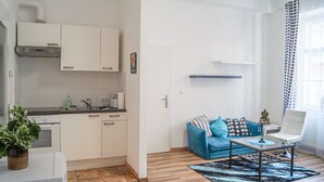 A modern apartment with a kitchen, a living area with a sofa and coffee table, and a window with curtains. - Modern Apartment in The Heart of Vienna 5 (Vienna)