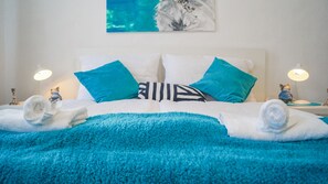 A neatly made bed with blue and white bedding, two decorative pillows, and a blue throw blanket. - Modern Apartment in The Heart of Vienna 5 (Vienna)
