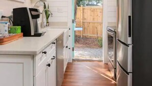 A kitchen with white cabinets, a stainless steel refrigerator, and a wooden floor. - Unbeatable Location - Beaches & DT - Kid Friendly (Mount Pleasant)
