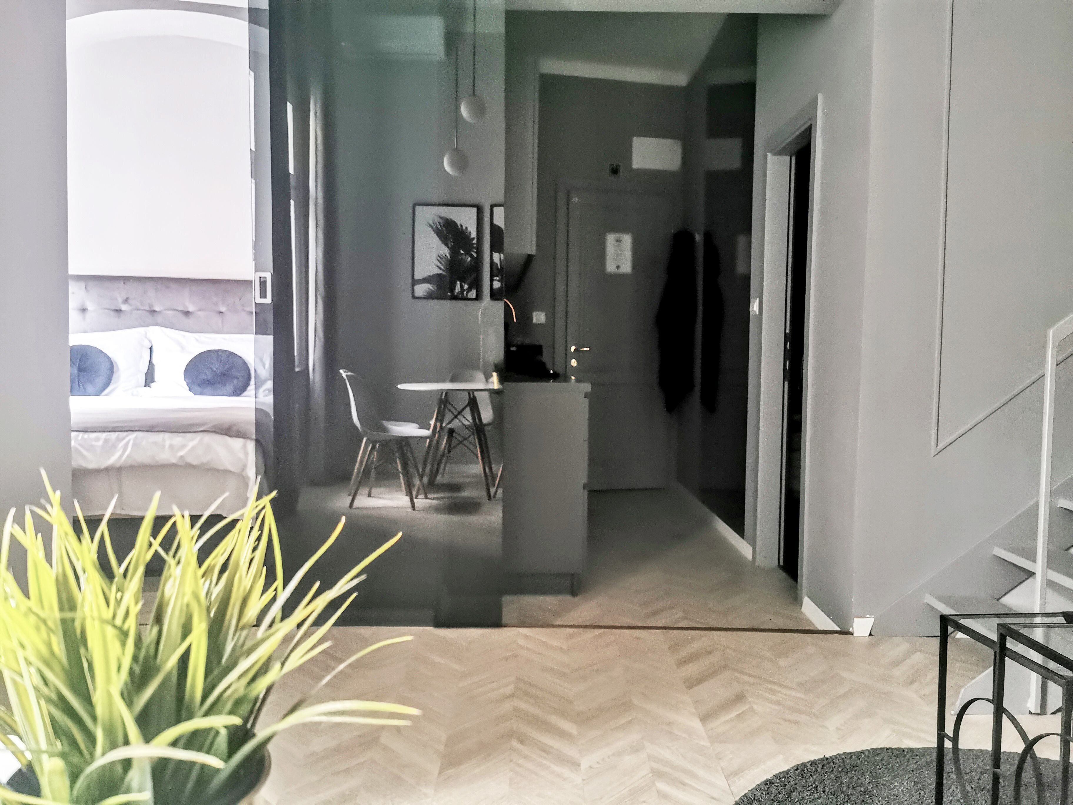 A modern interior with a dining area, kitchen, and a bed with a view.