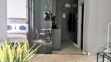 A modern interior with a dining area, kitchen, and a bed with a view.