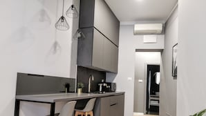A modern kitchen with a central island, bar stools, and pendant lighting. - Mint Boutique Studio Apartments  (Zagreb)